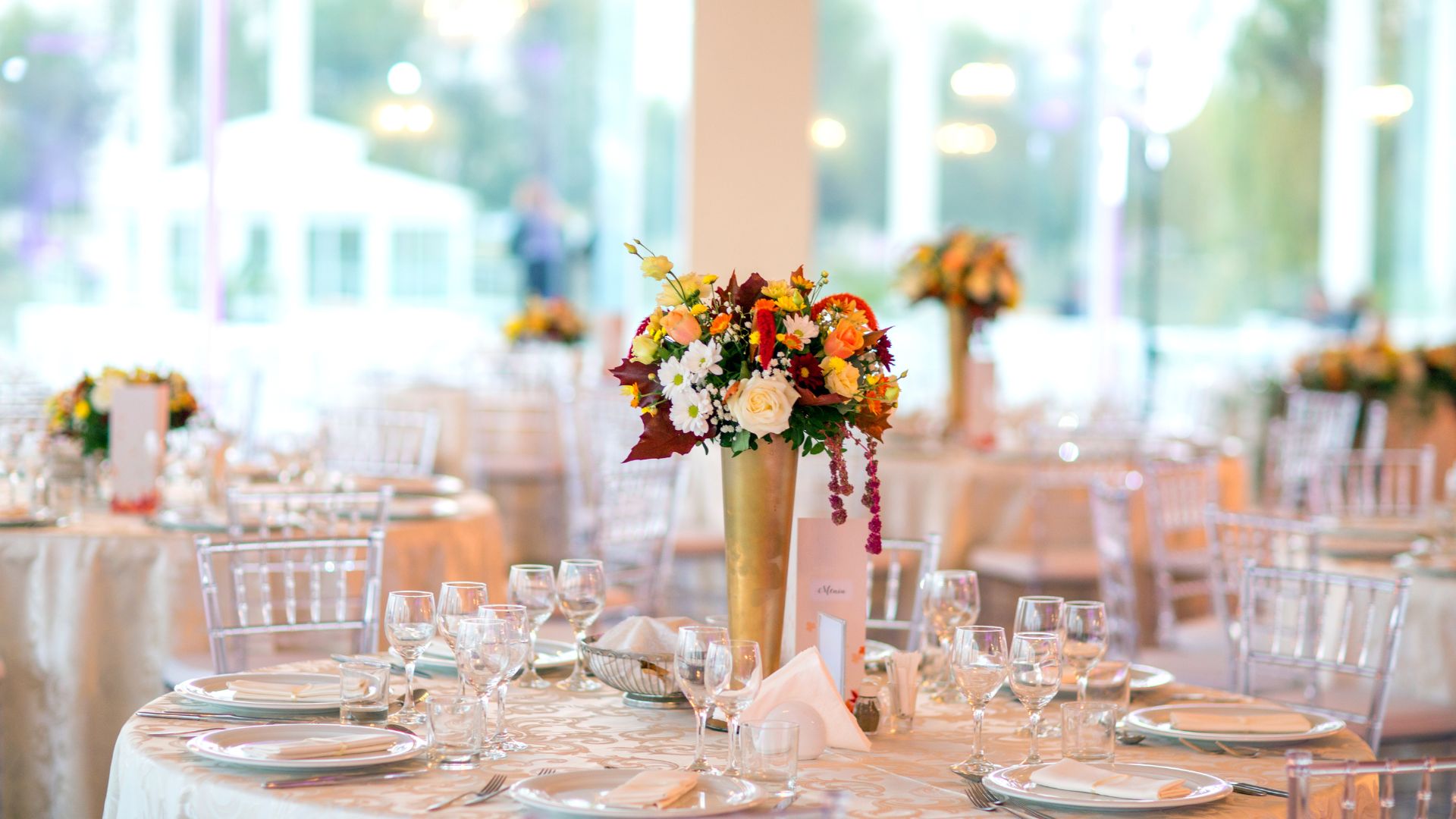 Dekoracje stołów z kwiatami i innymi elementami, których przygotowanie obejmuje organizacja imprez okolicznościowych.